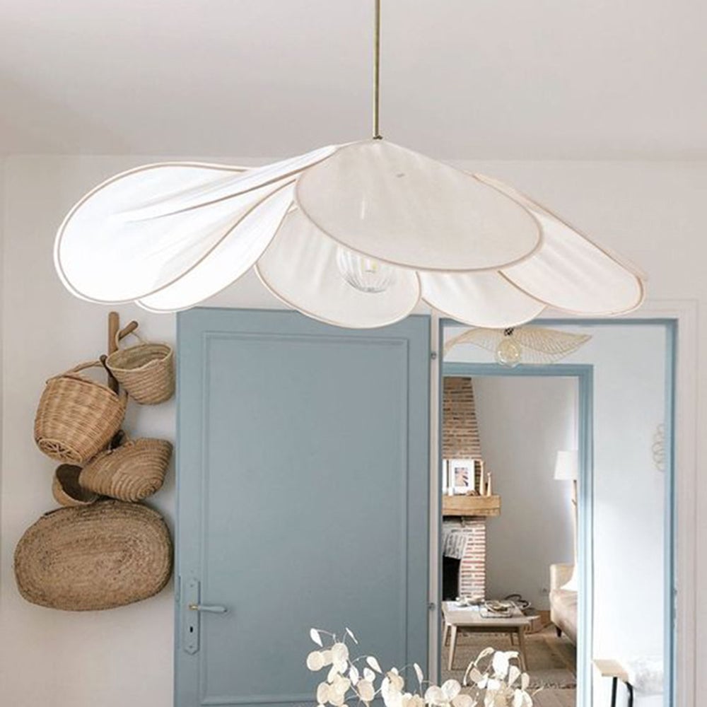 White Renée fabric-petal shade with gold-tone edging, hanging before a blue-grey door and mirror beside woven baskets.