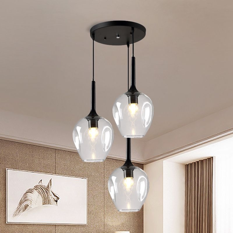 Clear glass cluster pendant with three shades near horse artwork and a curtained window