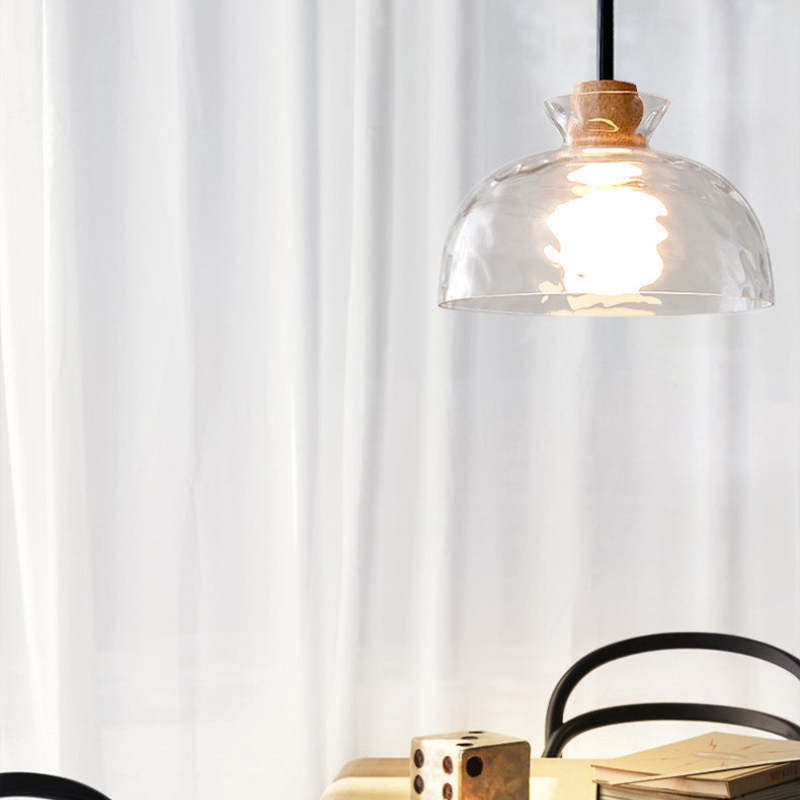 Rounded clear glass dome pendant above a light table