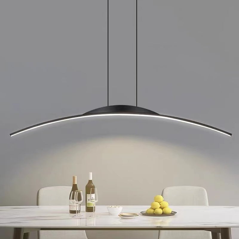 Louise black illuminated arc pendant above a table