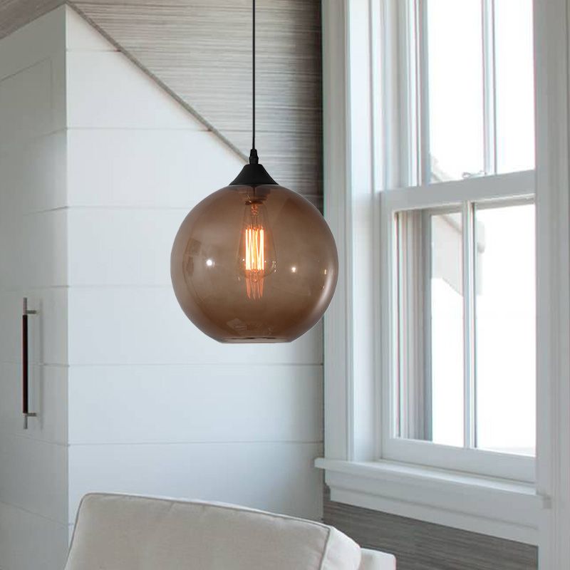 Coffee tinted glass globe pendant beside a window