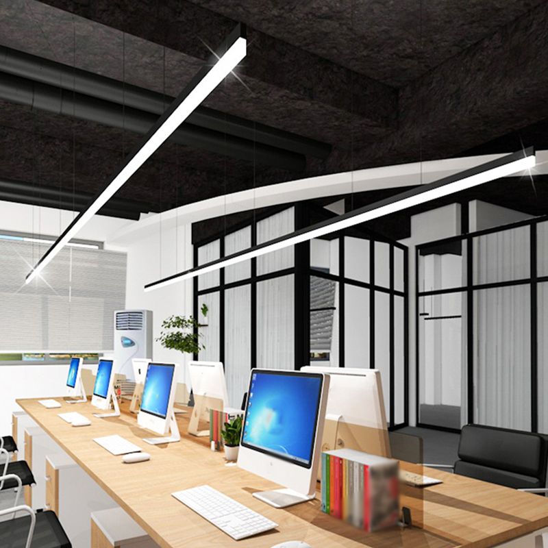 Angled view of illuminated linear pendants over office workstations.
