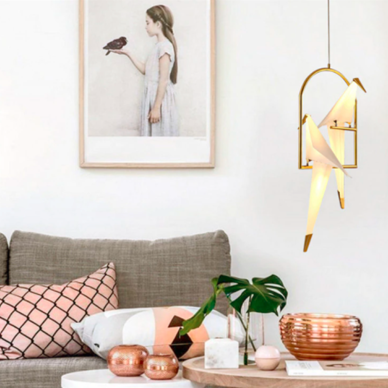 Two-bird pendant above a living-room table beside a sofa.