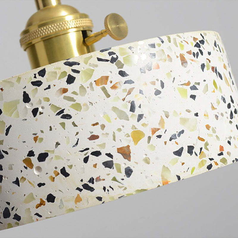Close-up of pale speckled shade surface and gold-tone holder with a round side knob