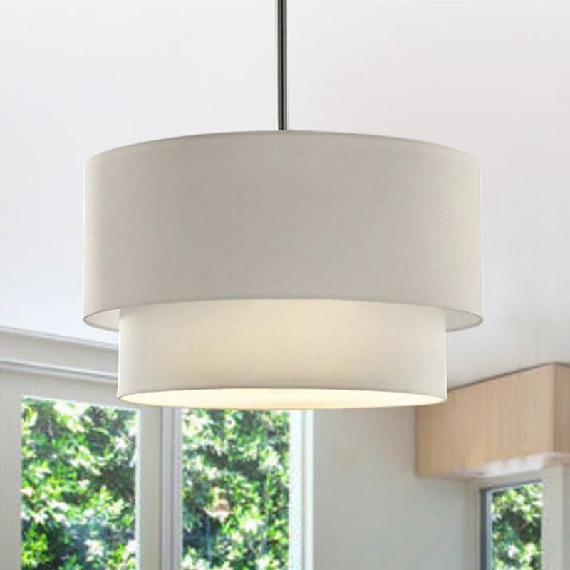 White Renee dual-drum pendant with a pale glowing underside beside a window.
