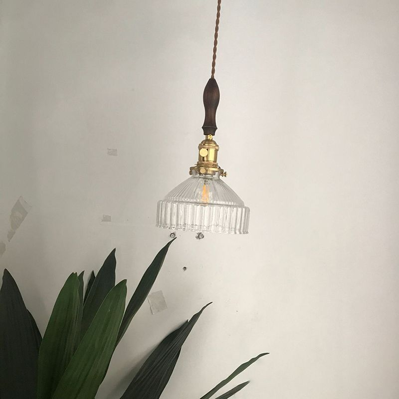 Cairns Black variant glass pendant with a dark upper spindle beside a plant