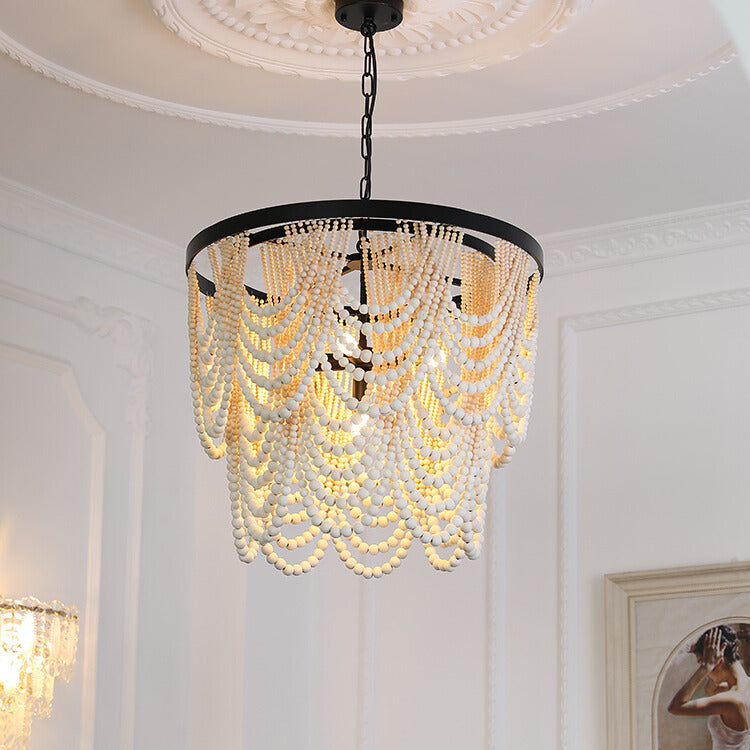 Light natural-tone bead pendant under dark ring in room