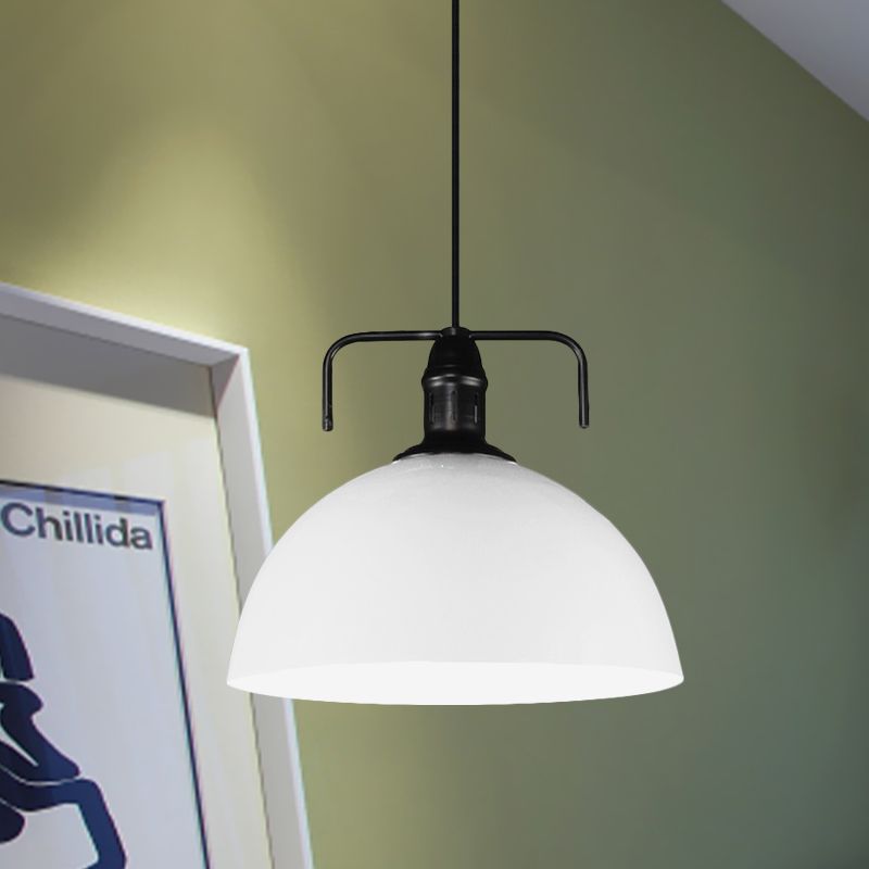 White dome pendant against green wall