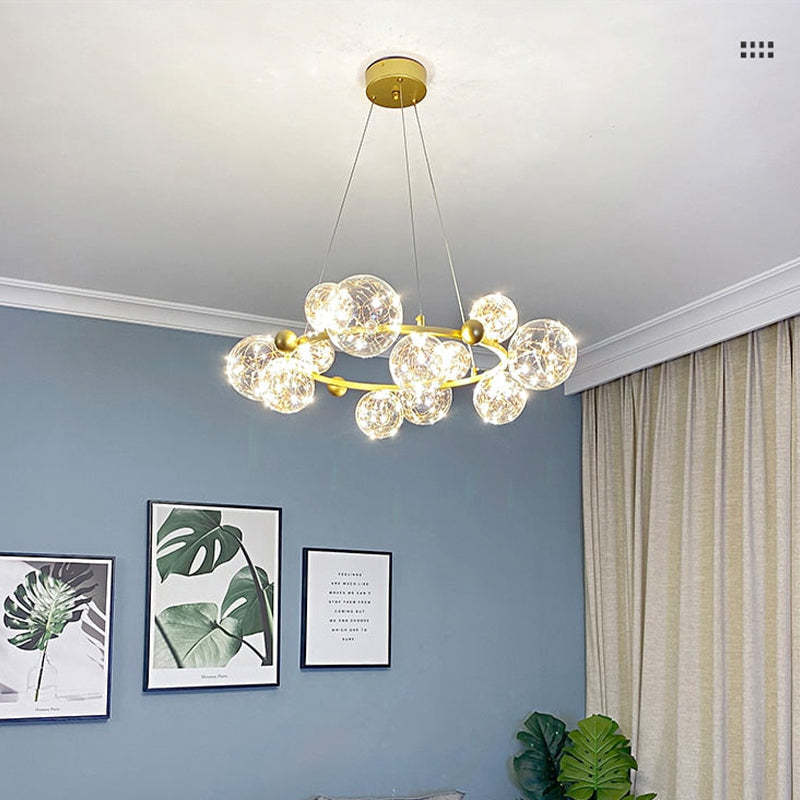 Gold ring chandelier in room with plant prints