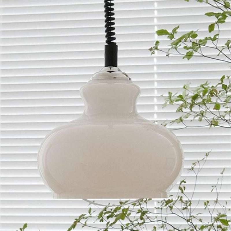 White glass pendant in front of window blinds