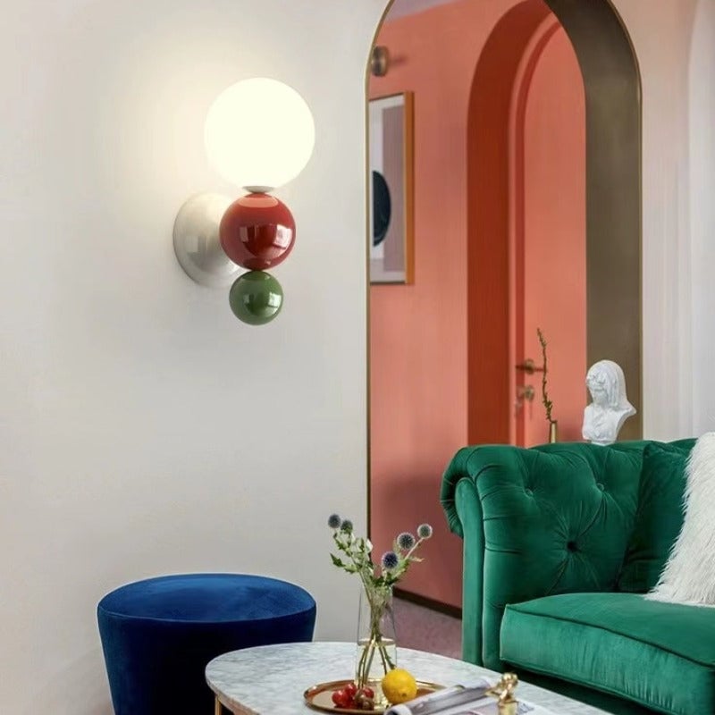 Green-option Valentina wall light with red centre and green lower sphere beside an arched doorway