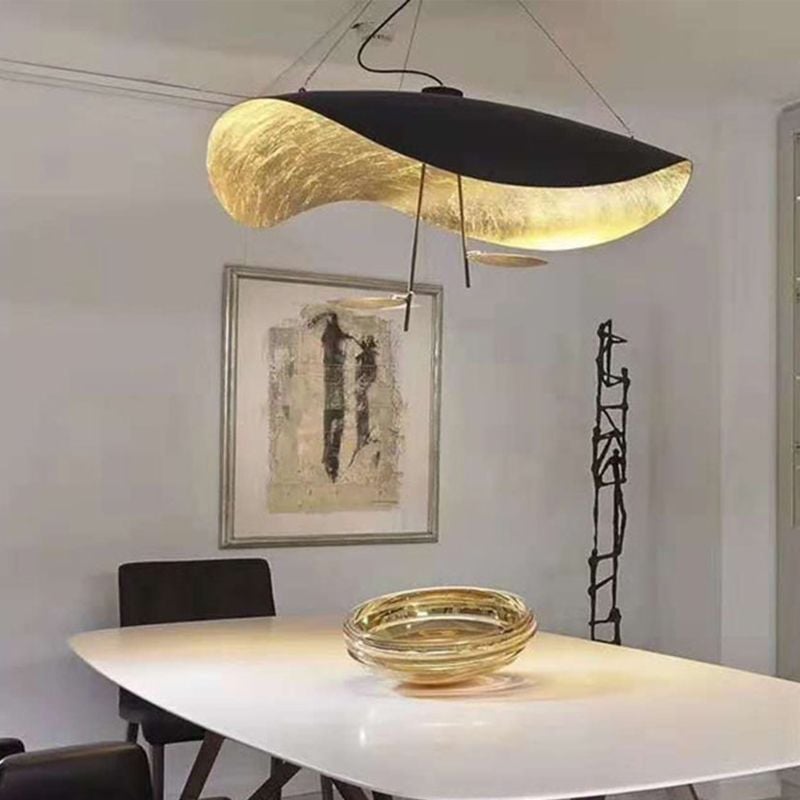 Black-and-gold Renée pendant above a pale dining table