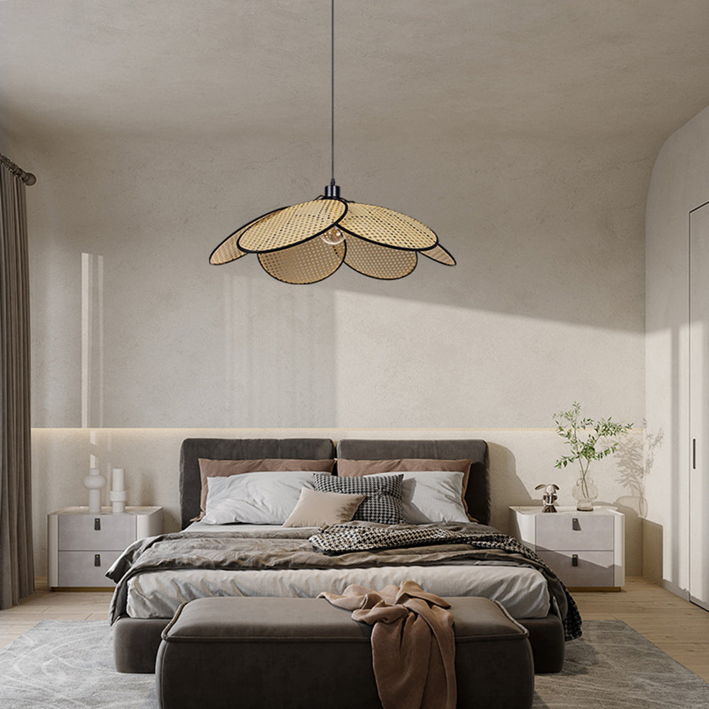Black-trim Ritta petal pendant above an upholstered bed, with white bedside tables, bench and leafy branch vase