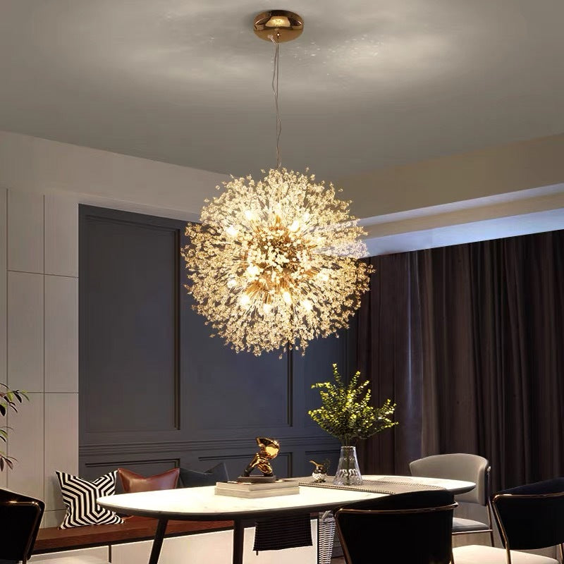Gold Lili sphere and round canopy above oval white dining table, black chairs and cushioned bench against blue panel wall