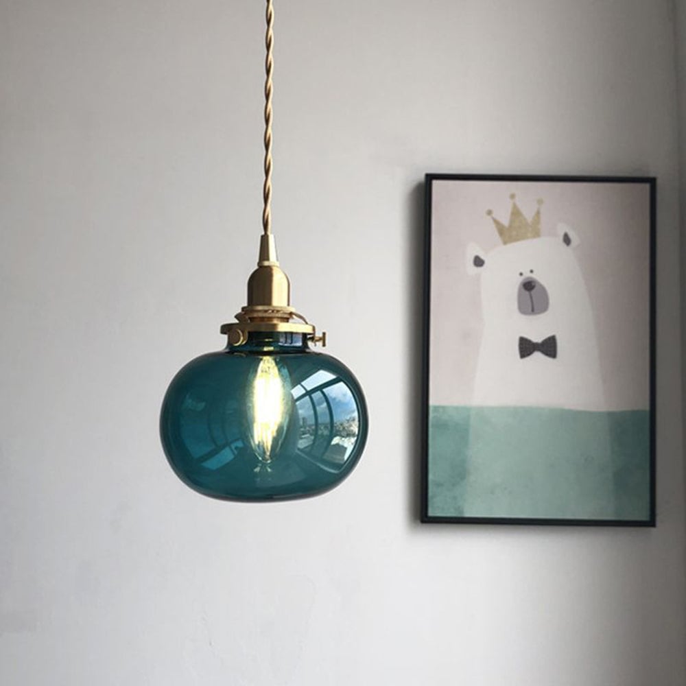 Blue-green ribbed oval glass pendant beside wall art