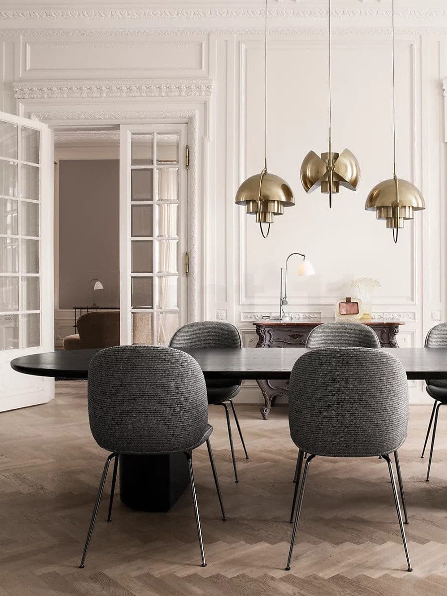 Three copper-finish pendants above grey dining chairs