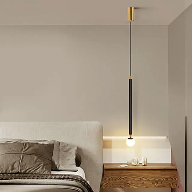 Carr Style B Black rod with gold-tone fittings and white globe beside a bed above a wooden nightstand with small ornaments