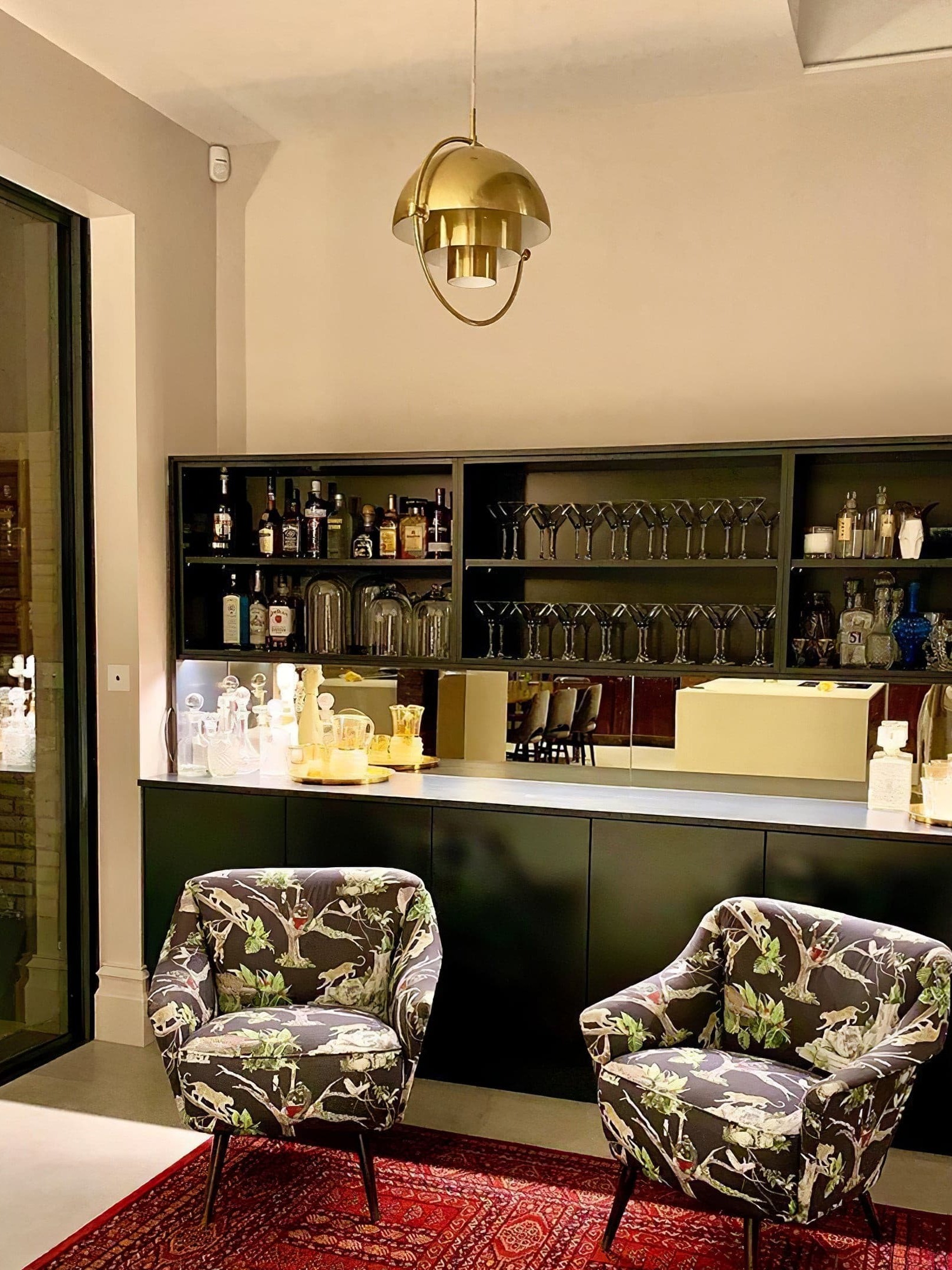 Copper-finish metal pendant in a room with a drinks cabinet