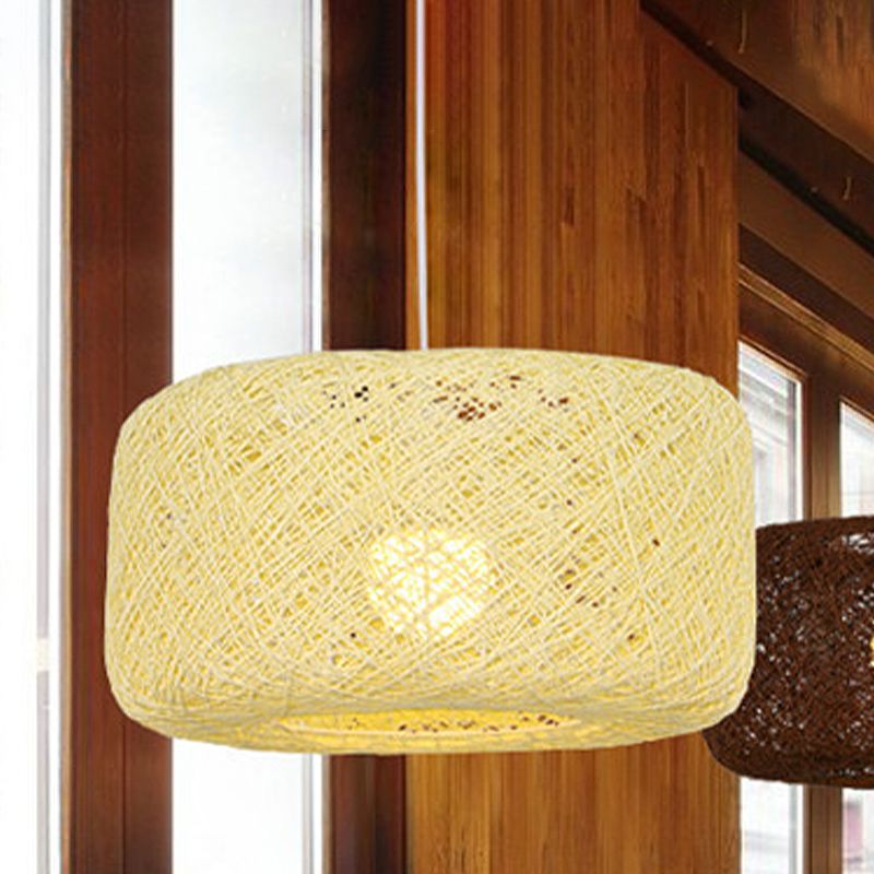 Pale straw coloured woven rattan pendant near timber wall