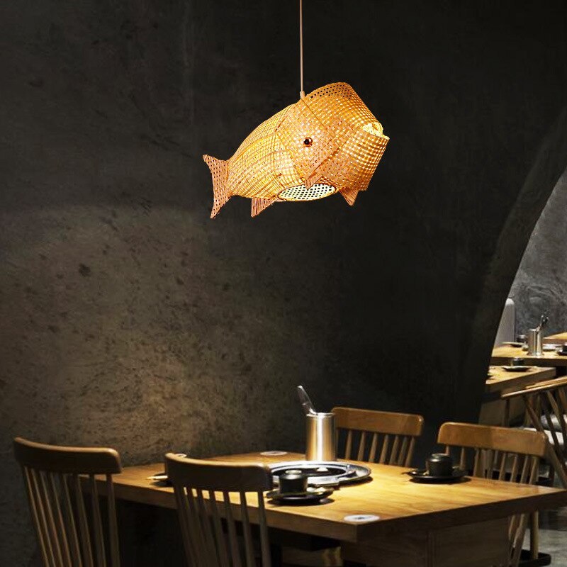 Muto woven fish pendant over a small restaurant table against a dark wall