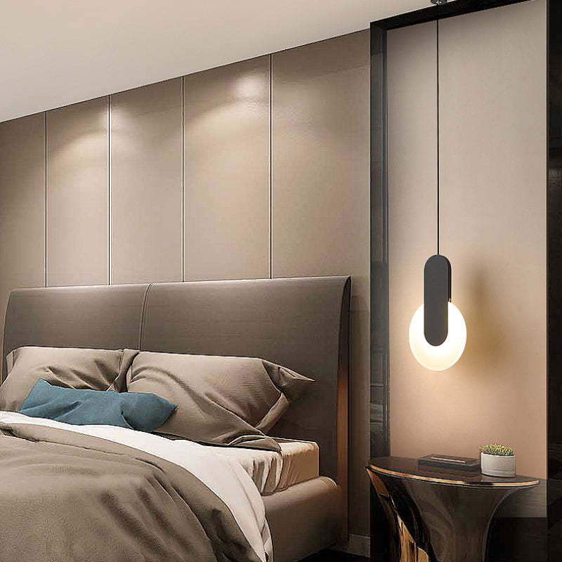 Black bar and round light pendant beside bed