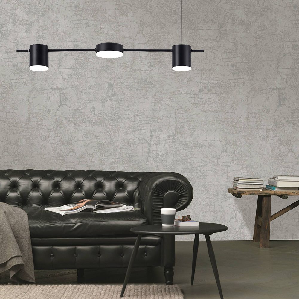 Black three-light linear pendant above sofa