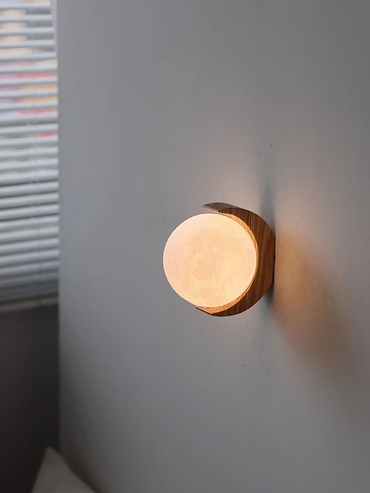 Opposite-side view of a glowing moon globe with the wood crescent to the right and blinds to the left