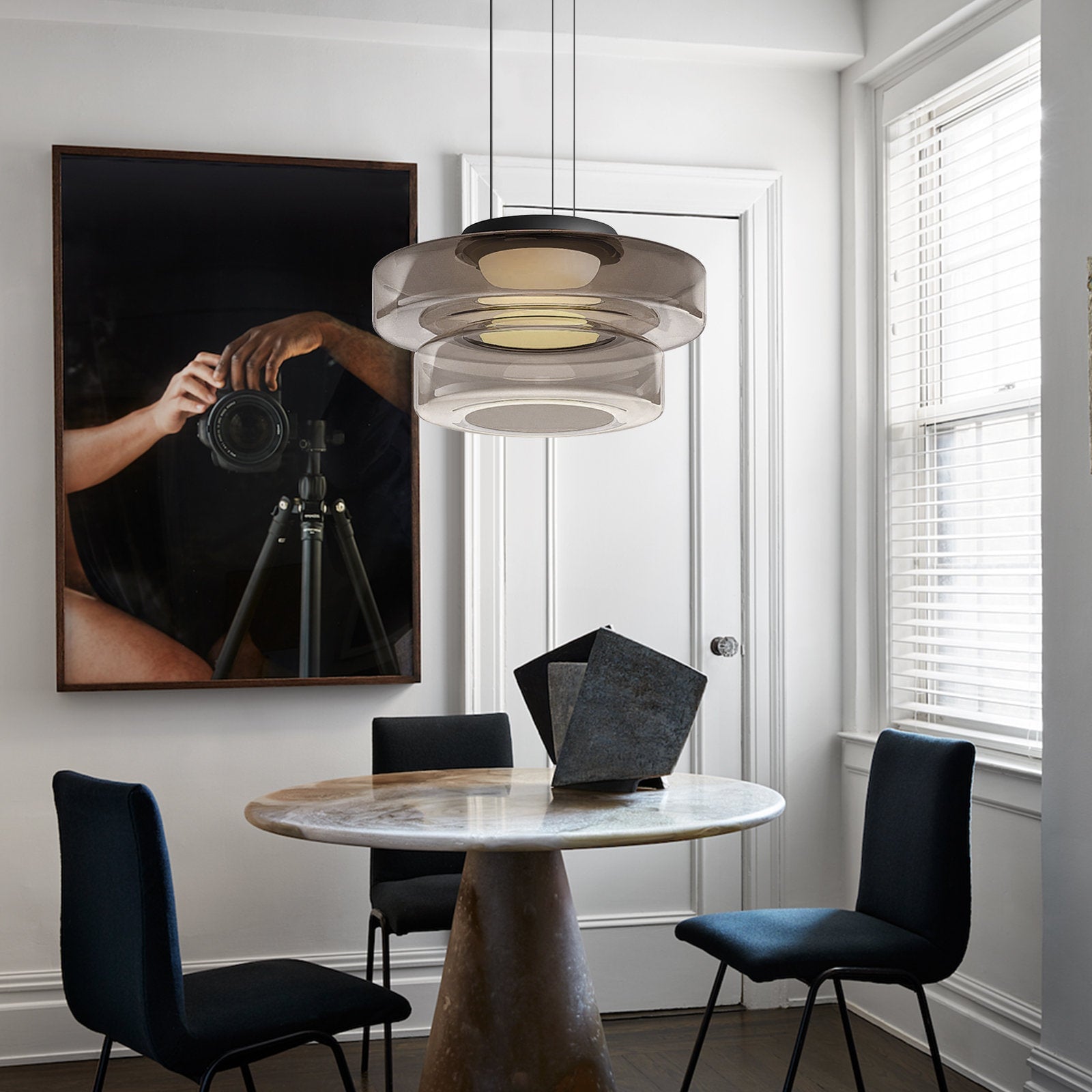Smoke-grey two-layer pendant over round dining table