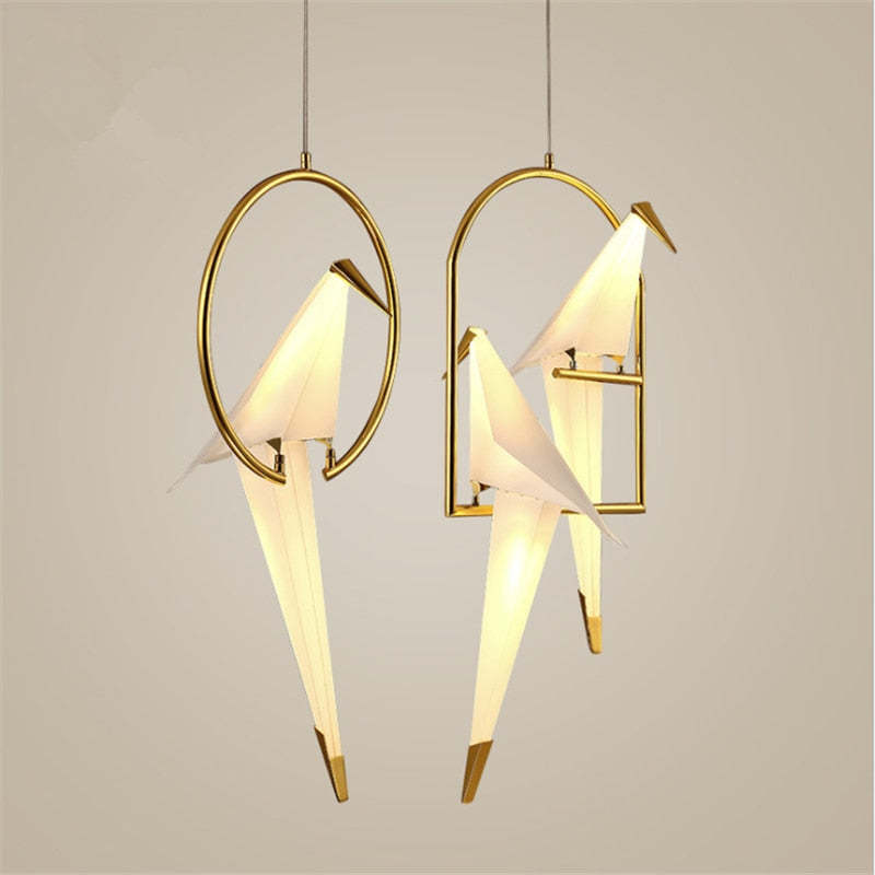 Illuminated bird pendants shown in oval and arched gold-coloured frames.