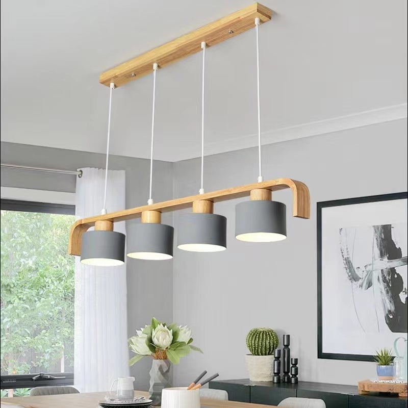 Angled view of four gray shades on a wooden frame above a dining table near a window and framed artwork