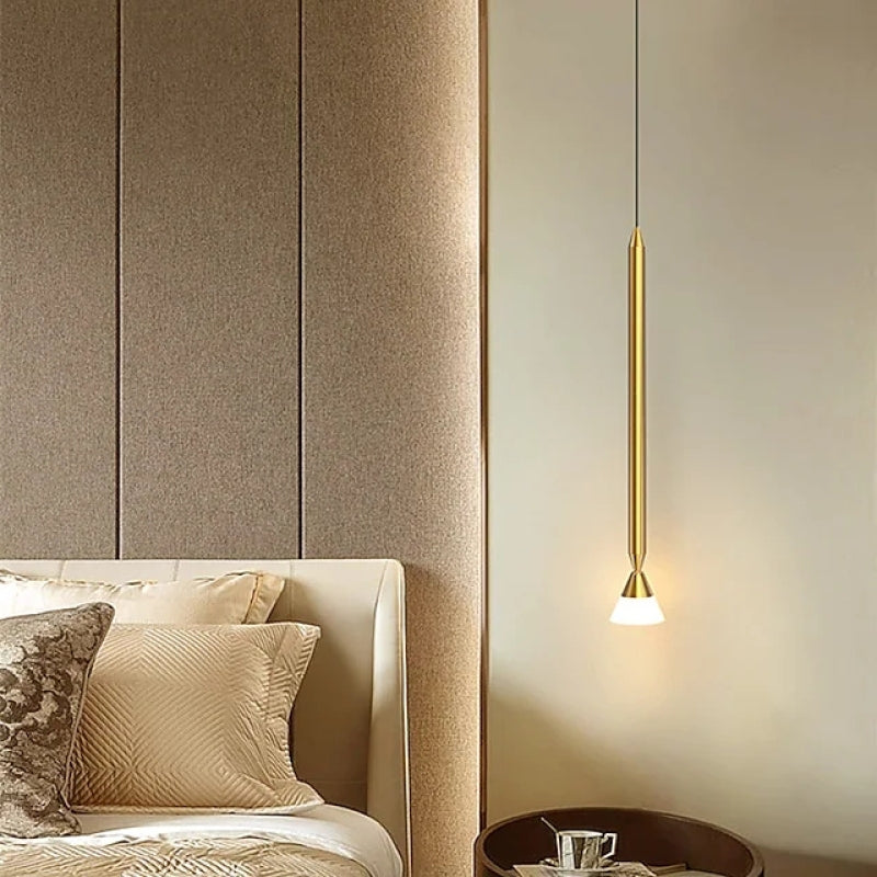 Carr Style A Gold rod pendant with a small white cone beside an upholstered bed and rounded side table against a panelled wall