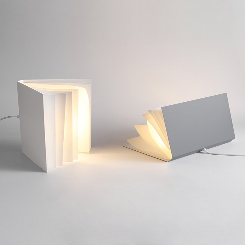 Two Sienna book-shaped shades resting in upright and sideways positions on a pale surface, with cords visible