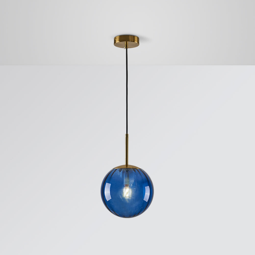 Blue tinted glass globe with a glowing bulb, gold-tone stem, round canopy and black cord against Gray