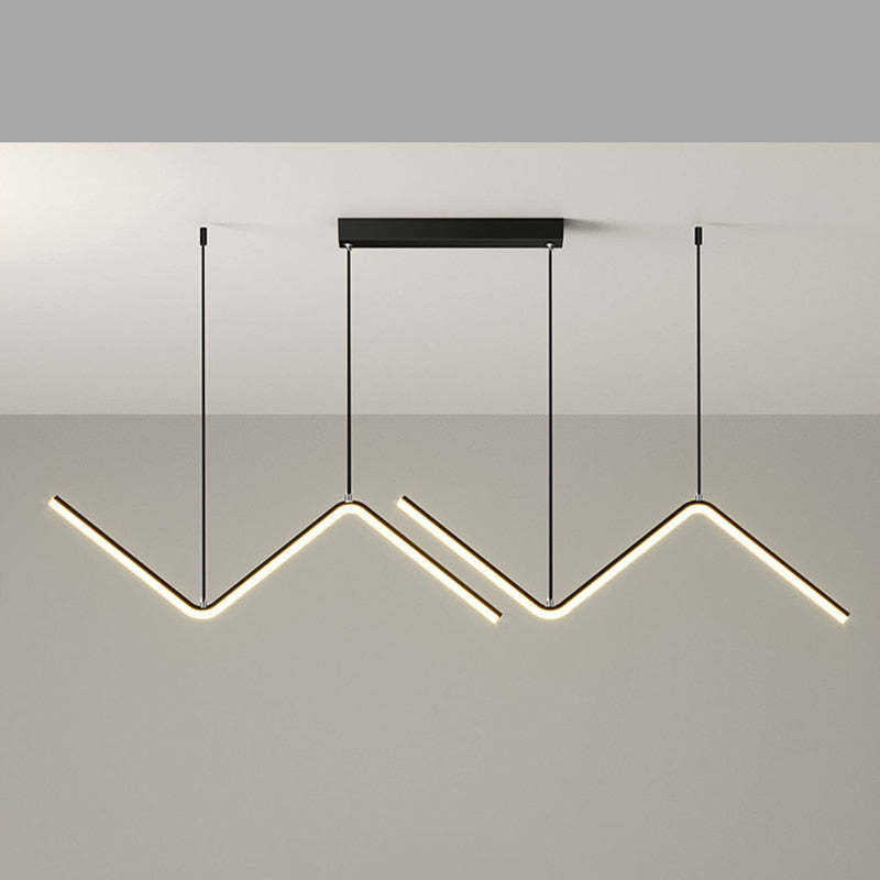 Front view of black double-wave pendant with lit undersides against a gray wall beneath a pale ceiling