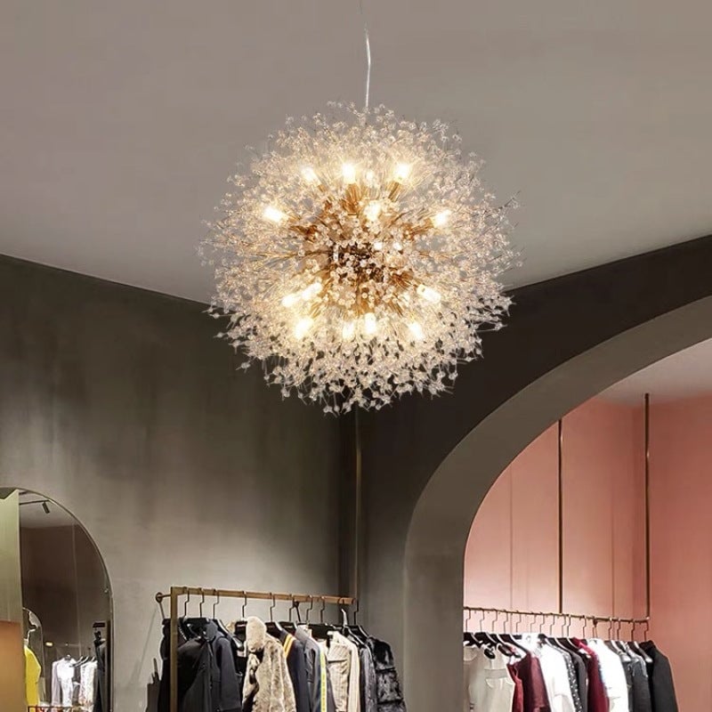 Gold Lili dandelion pendant above clothing rails near curved arch and mirror in shop interior
