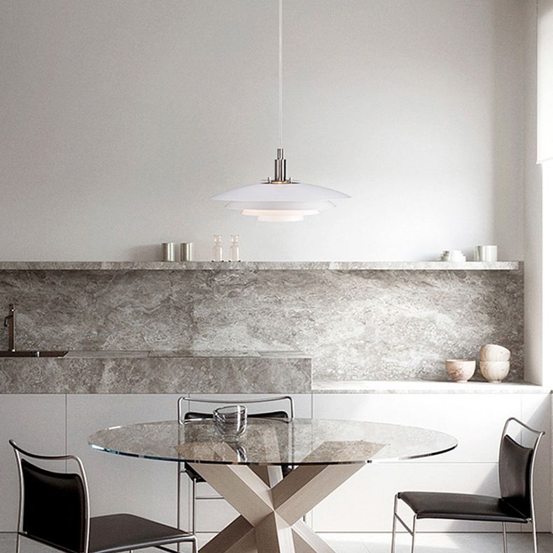 Single white layered pendant above round dining table