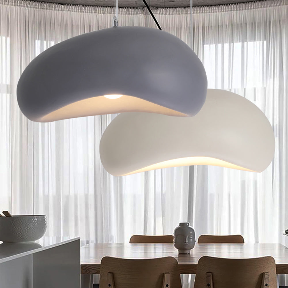 Gray and White Byers curved bread-shaped shades hanging at different heights above a wooden dining table in front of sheer curtains.