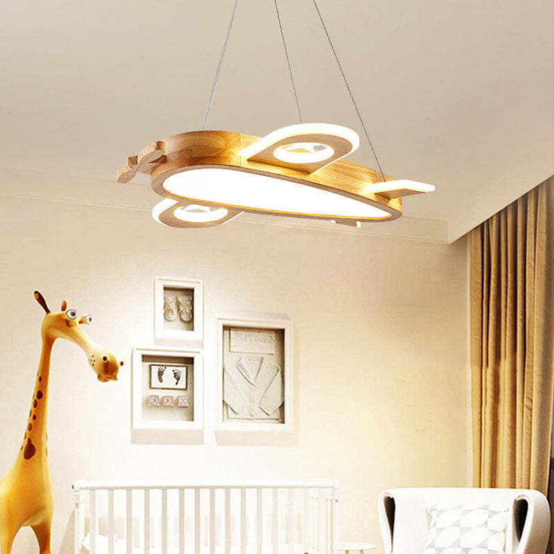 Airplane pendant above a white cot beside a giraffe toy, chair and brown curtains