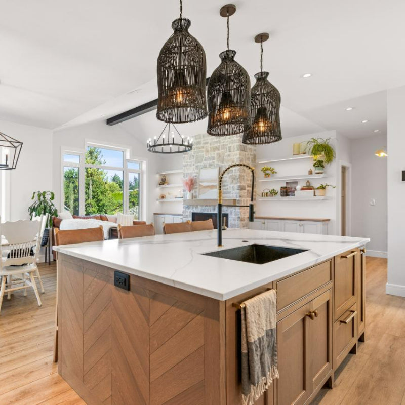 Three black cage-form pendants above a kitchen island