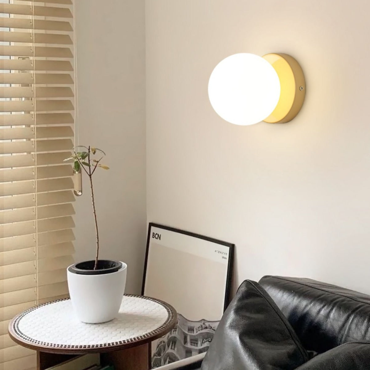 Yellow wall light above side table near a chair