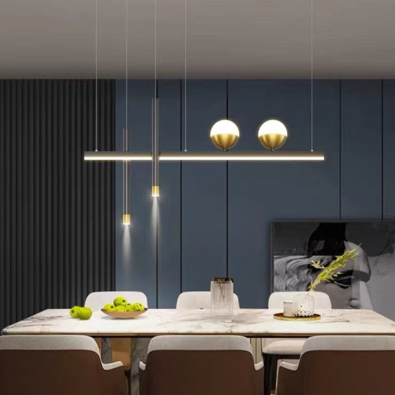 Madina two-globe pendant above a dining table with pale chairs.