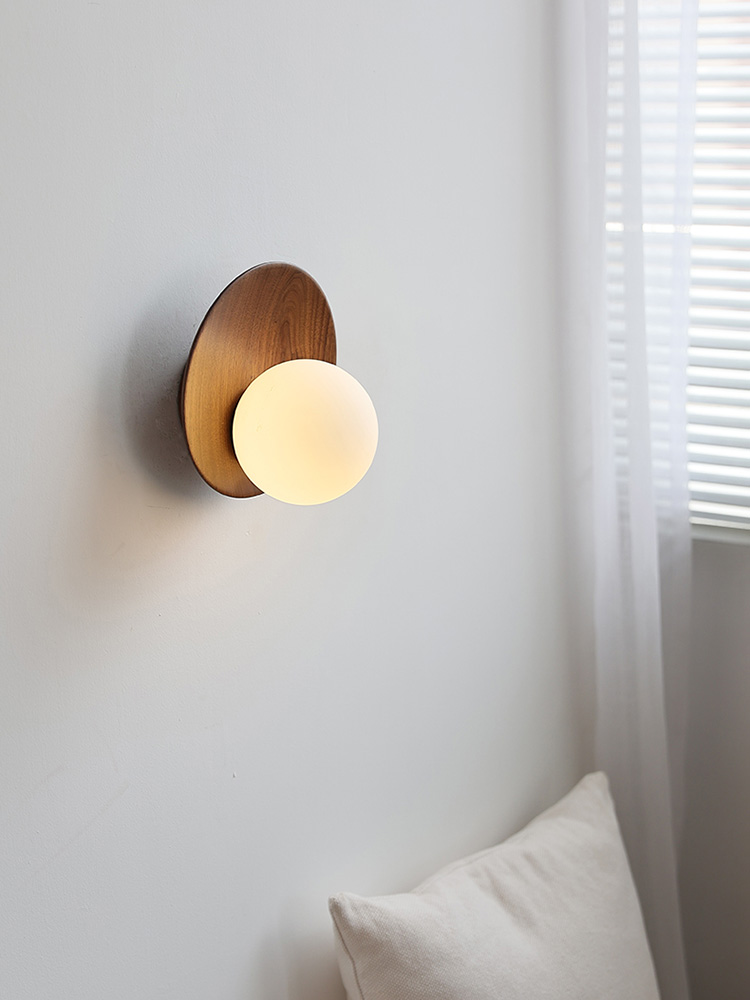 Close view of the glowing Lunetta globe and walnut disc