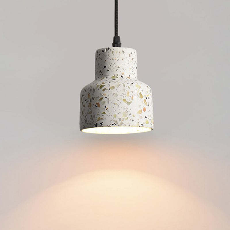 Stepped-neck speckled shade on a black cord with a glowing lower opening