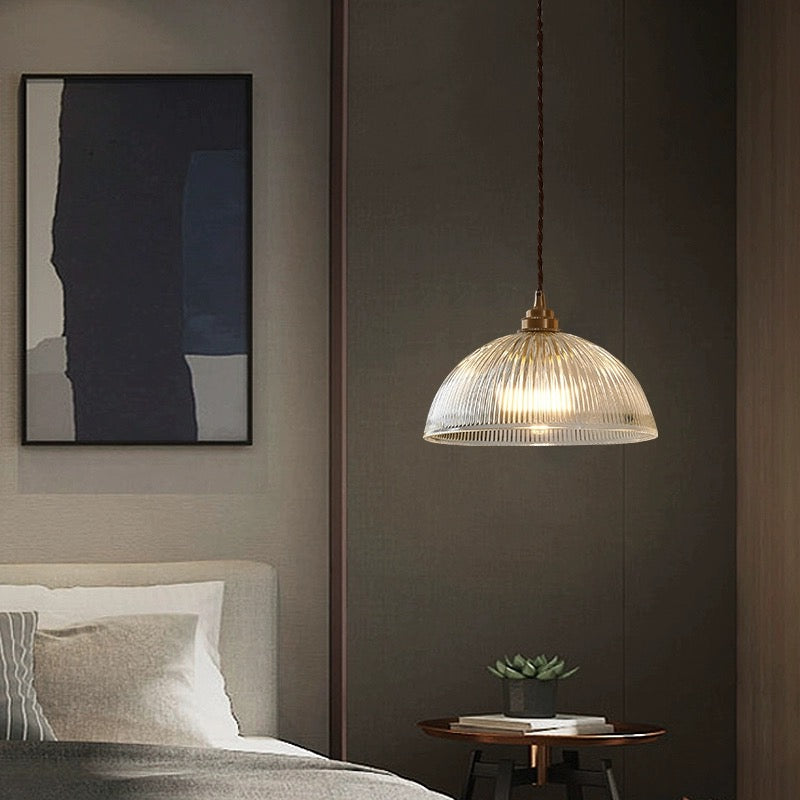 Alessio clear ribbed pendant above a bedside table beside a bed