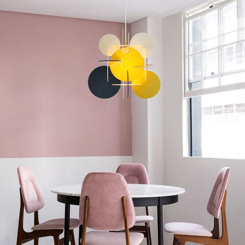 Morandi Yellow/Black/White pendant above a round white table and pink chairs beside a window