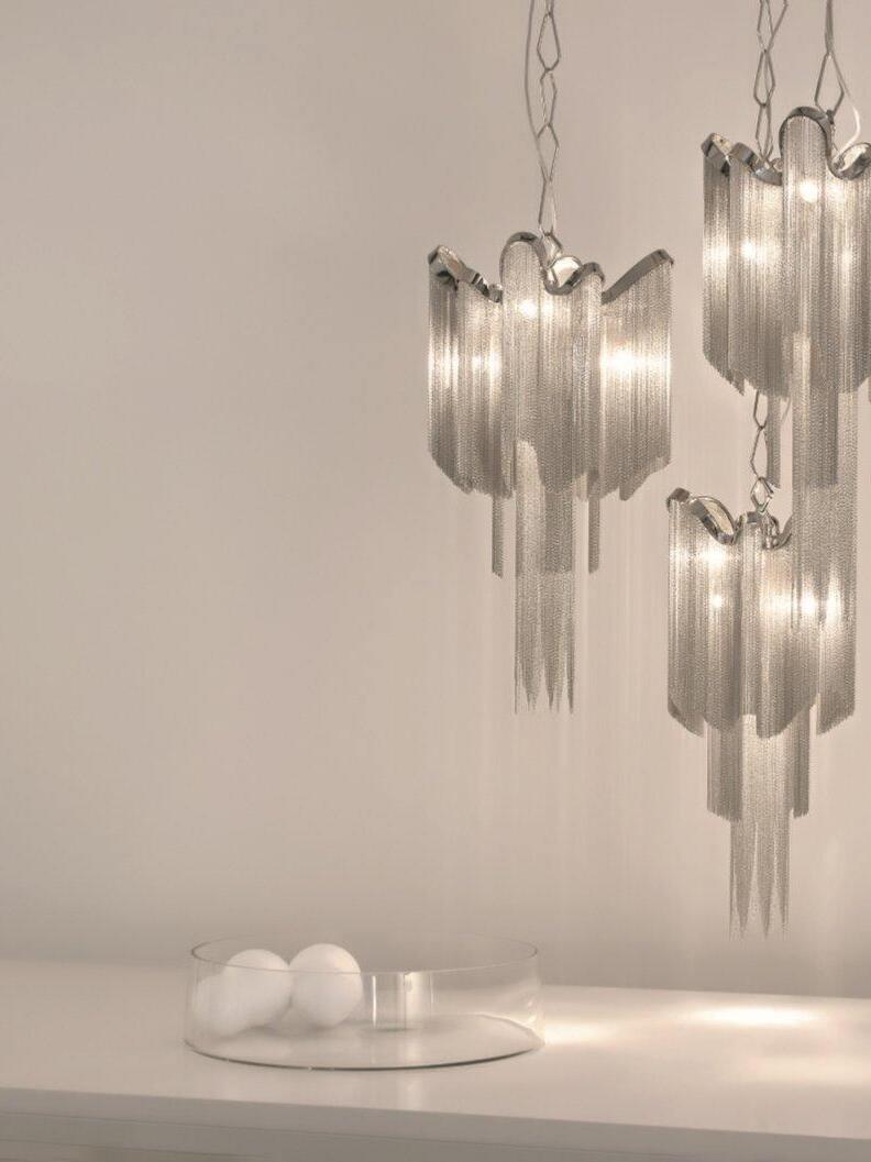 Grouped cascading chain fixtures beside a table