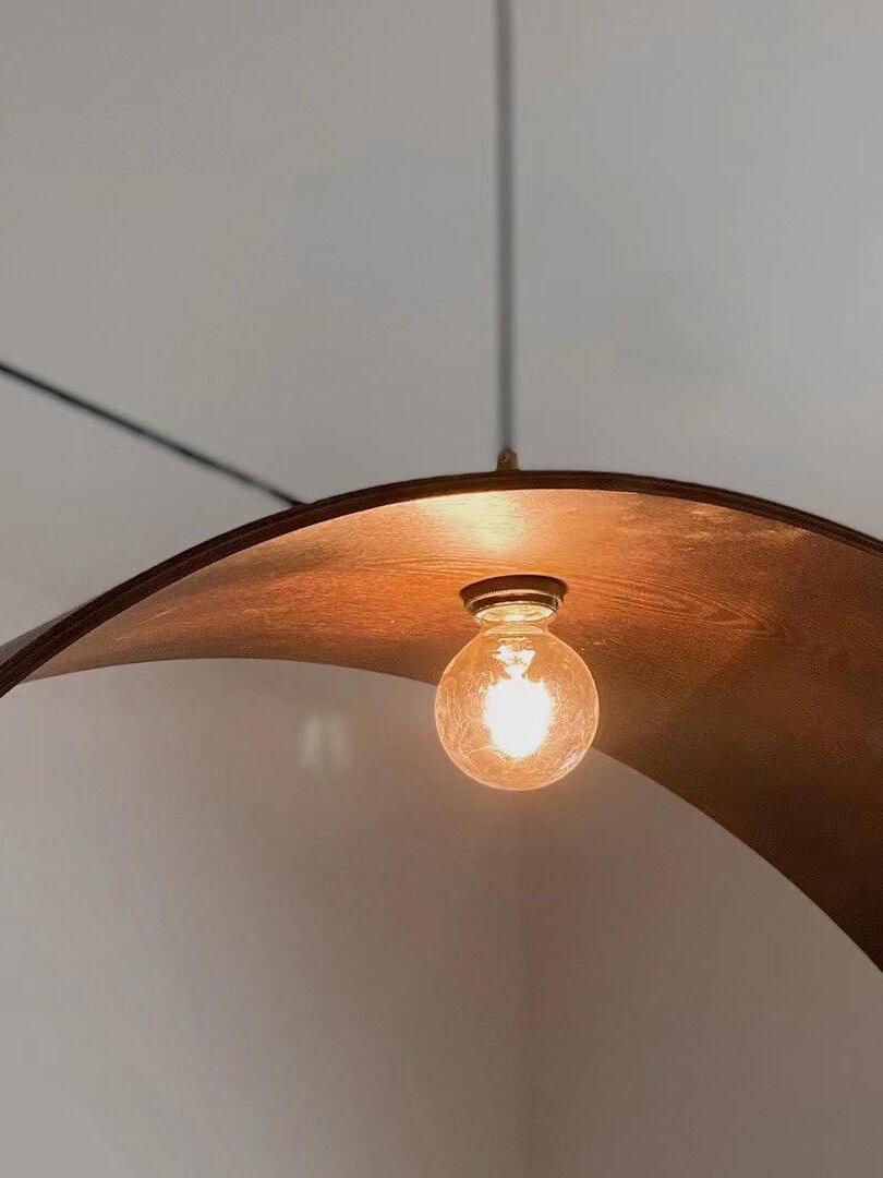 Low-angle view of the exposed bulb beneath the overlapping curved wooden wings