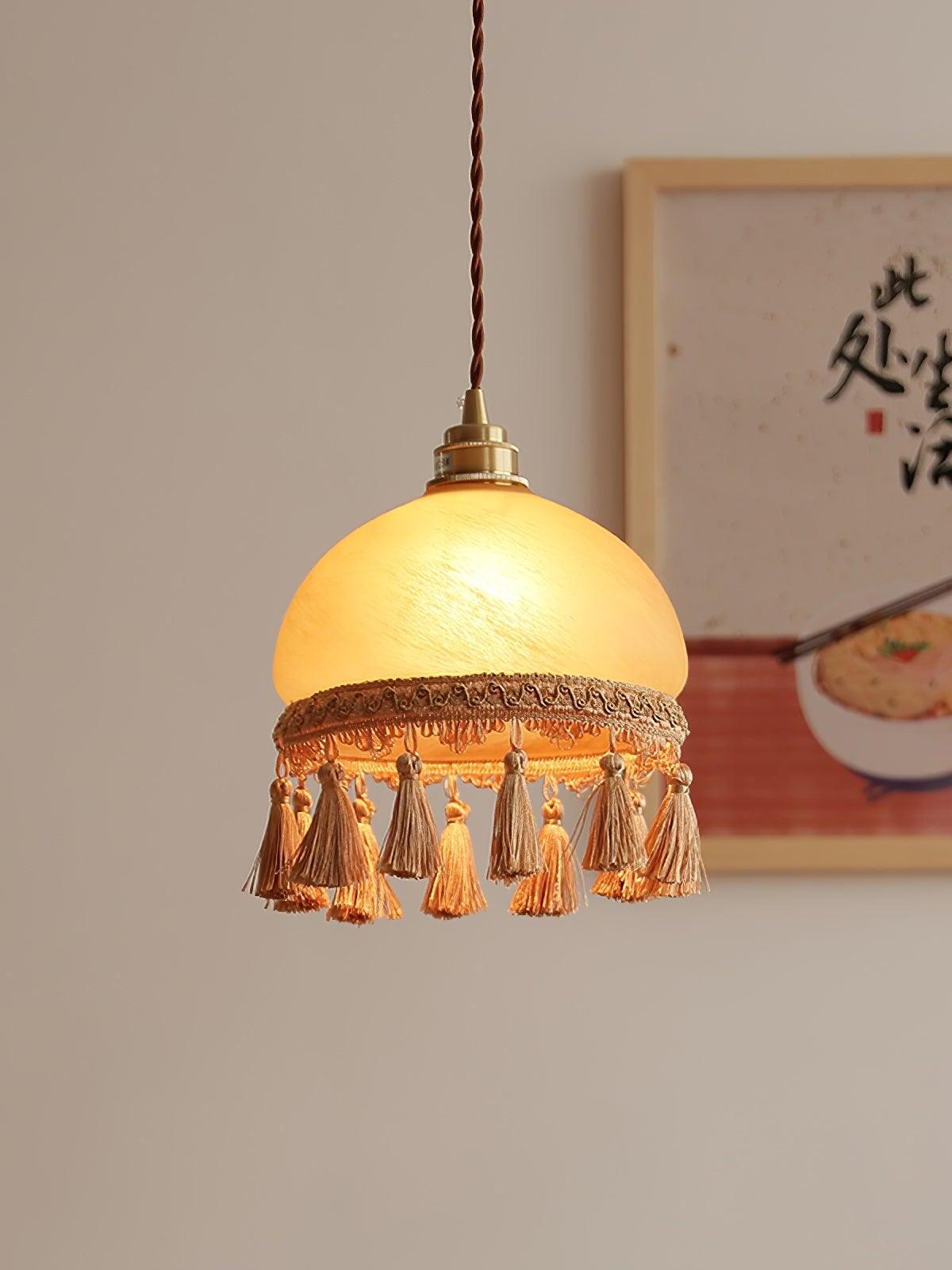 Yellow glass tassel pendant beside framed art