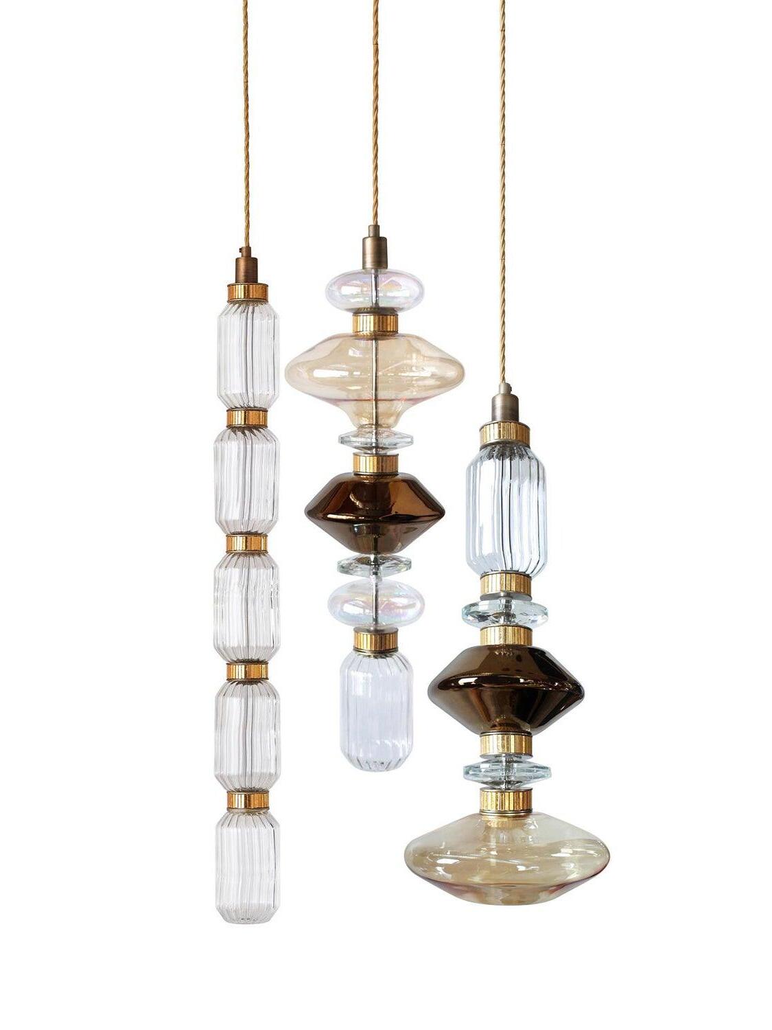 Three glass pendant forms including a long segmented piece