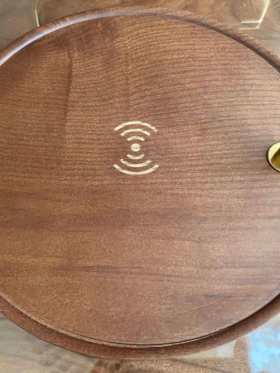 Close view of a wood-grain lamp base with a wireless-style symbol in the centre